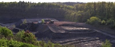 Blick in die Rettigheimer Tongrube, in der Bildmitte imponiert ein großer Tonberg mit Bagger obendrauf.